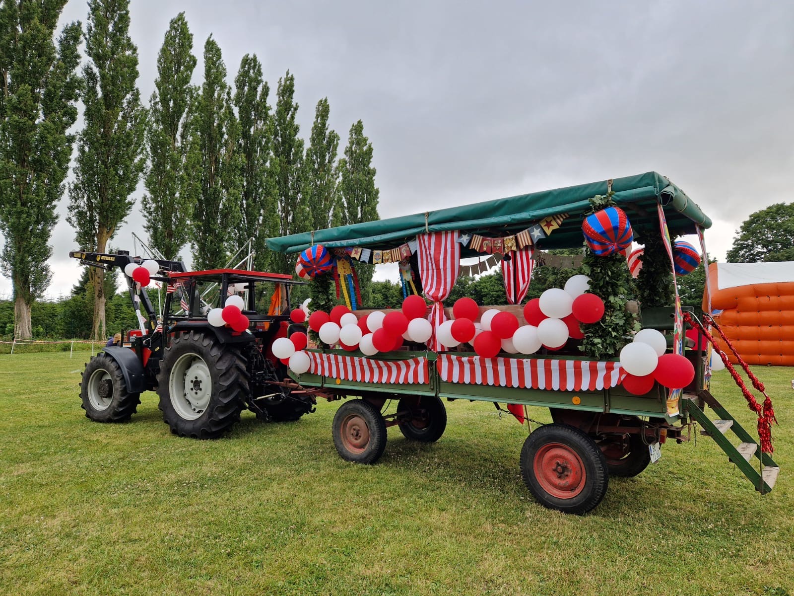 Traktor mit im Zirkus-Stil geschmückten Wagen